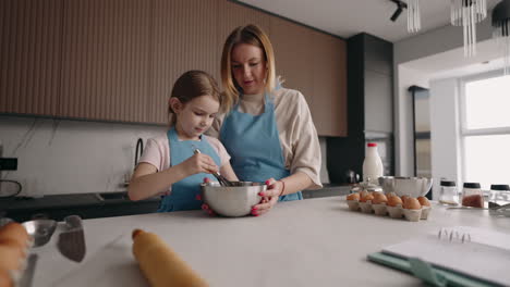 cooking-masterclass-for-children-adult-woman-and-little-girl-are-mixing-ingredients-in-metal-bowl